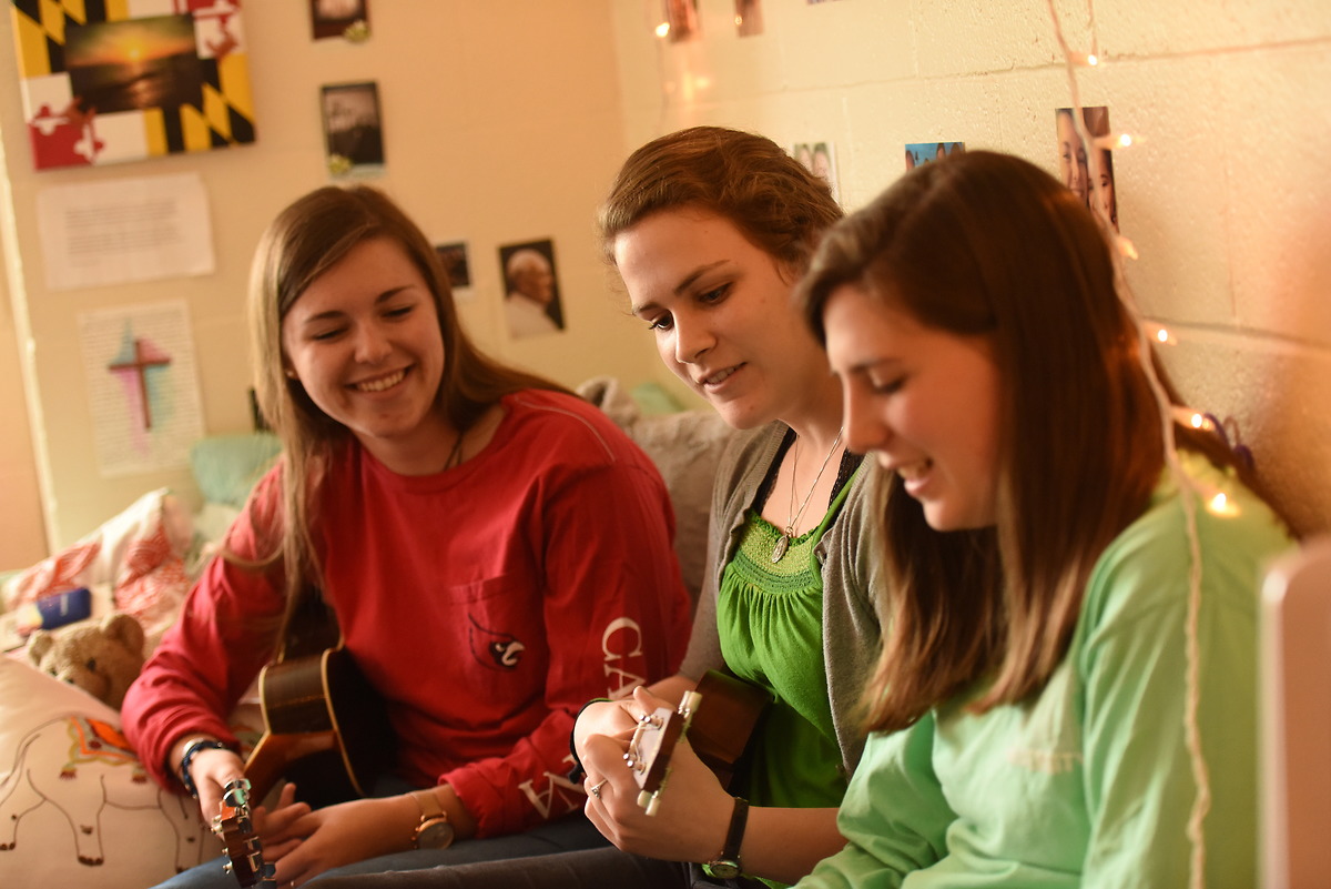女生们在宿舍楼的房间里弹奏尤克里里.