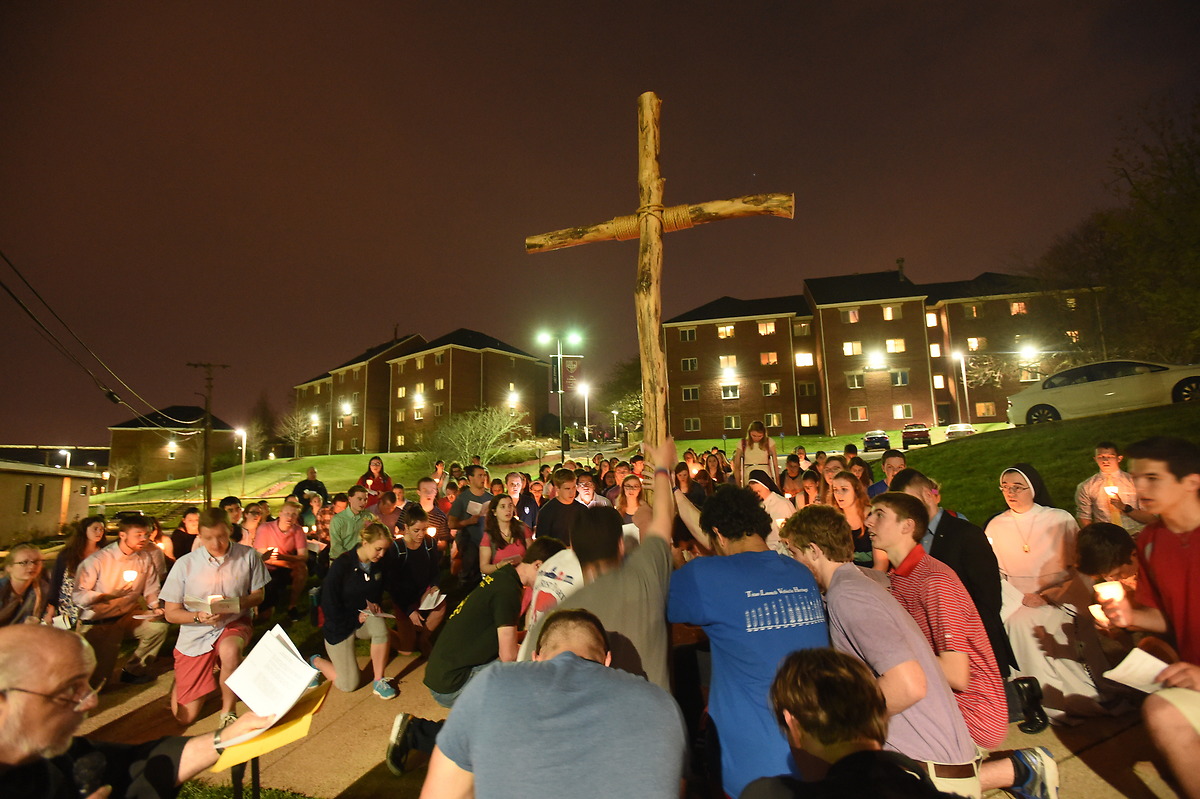 学生们跪在木十字架前