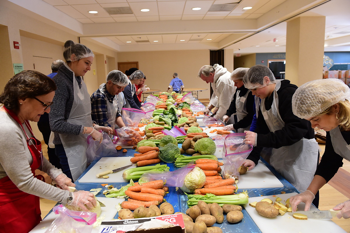 学生和加维校长在天主教大学一年一度的马丁·路德·金活动的服务场所切菜. Day of Service