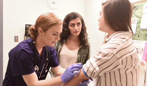 A nursing student taking a patient's blood pressure.