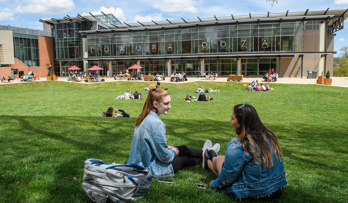 Students sitting on lawn in front of student center
