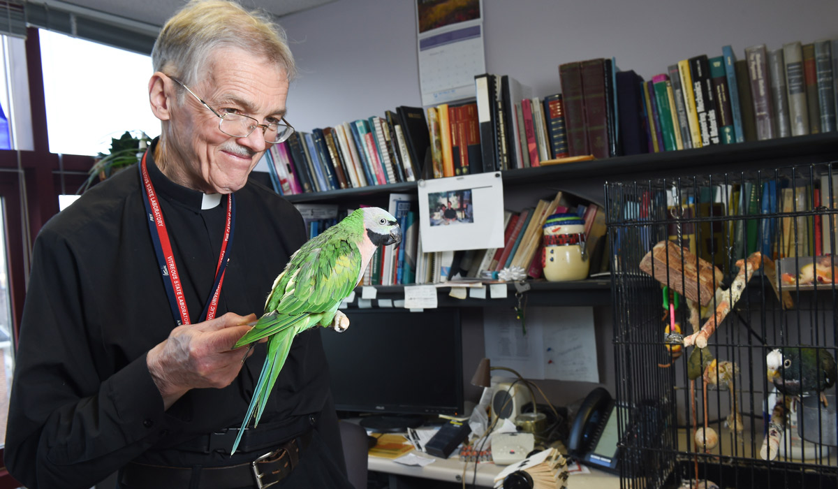 Father Andrew Buechele and his parrot