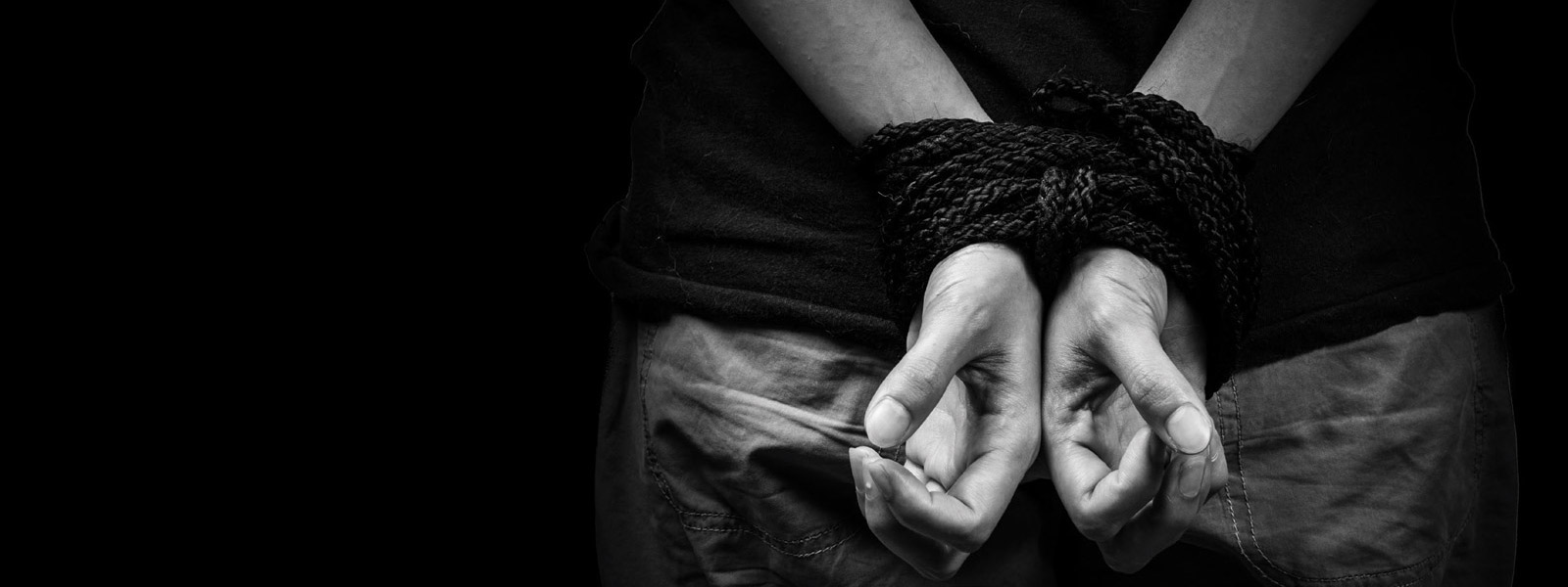 close-up of hands tied behind person's back
