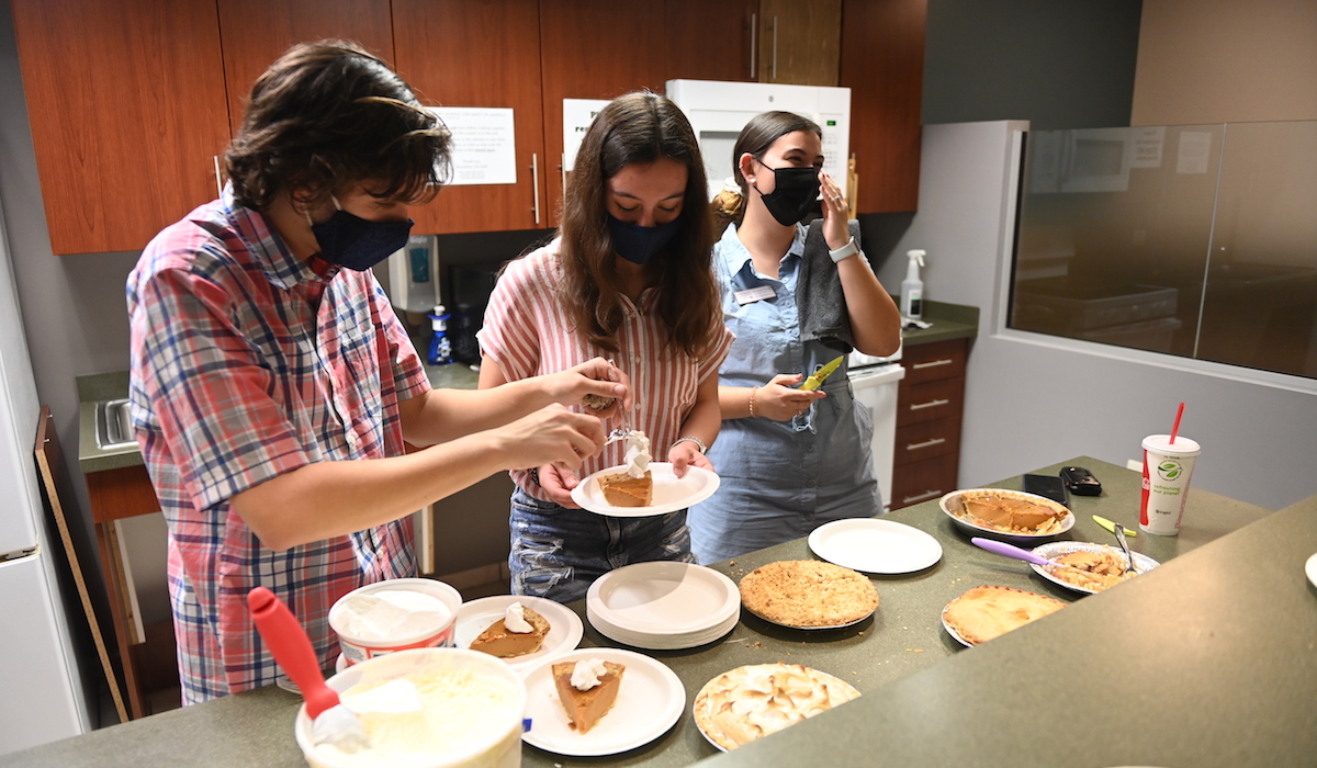 Students serve their friends pie in Opus Hall' common kitchen