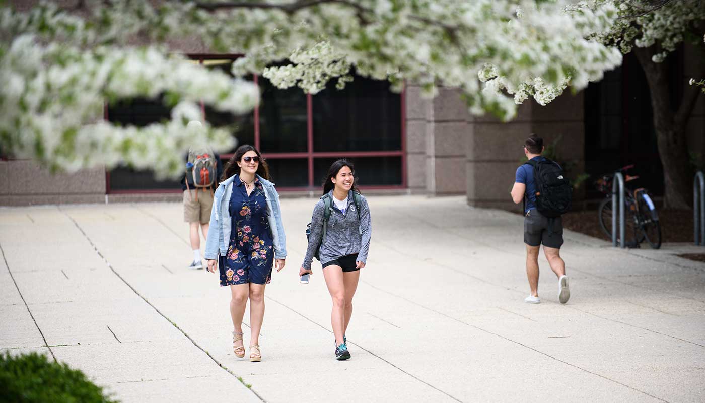 Two students walking in the springtime.