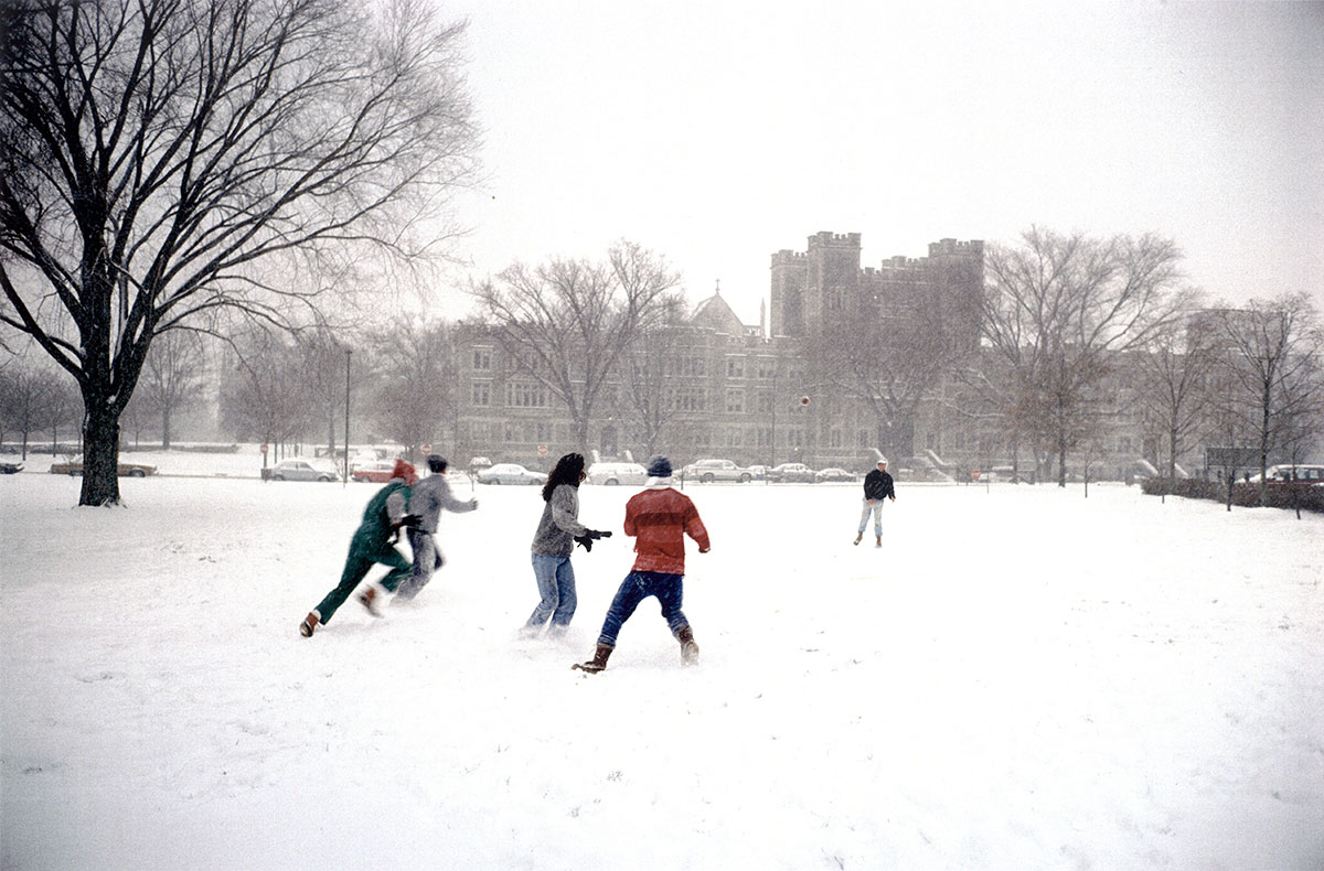 Students playing football in the snow