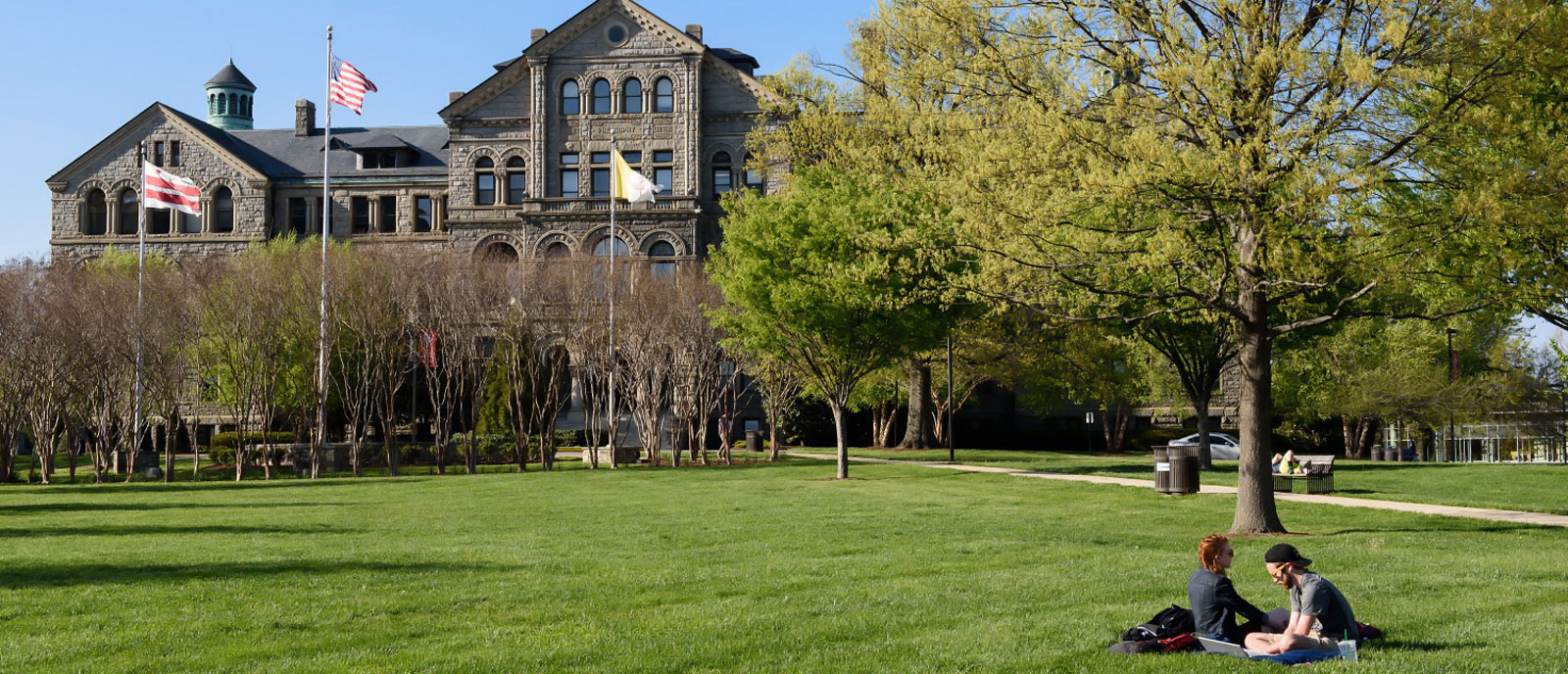 McMahon Hall with students studying on front lawn