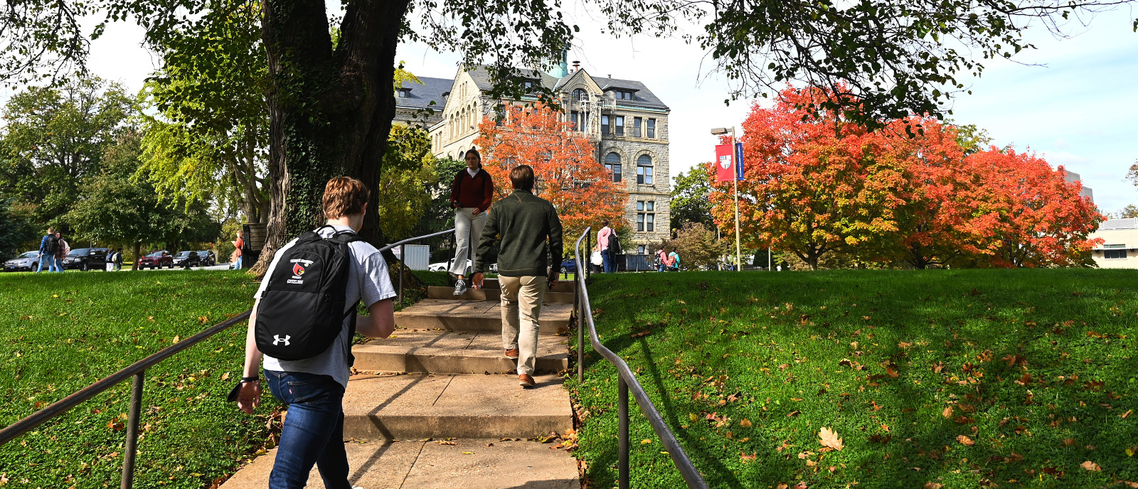 Students walking into fall foliage