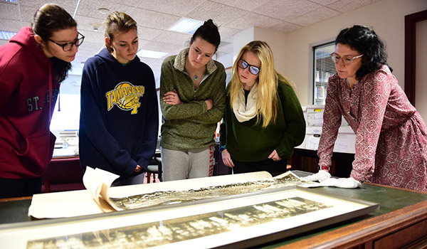 Professor and students looking over university archived photos