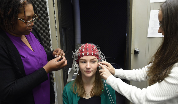 Students hooking a device up to another student in order to read brain waves.
