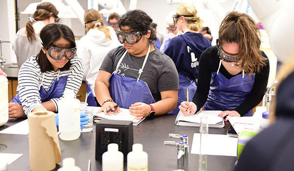 Students in a chemistry lab taking measurements.