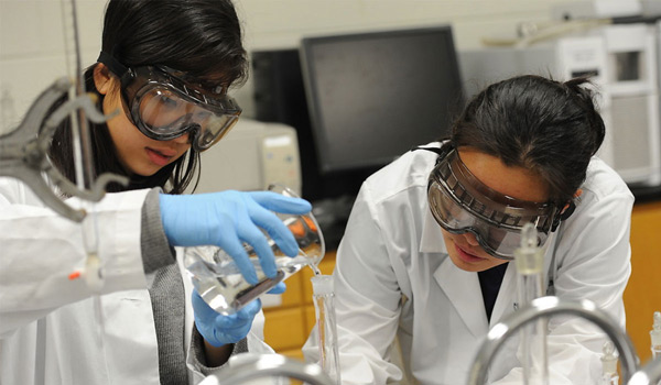Two students working in a chemistry lab. 