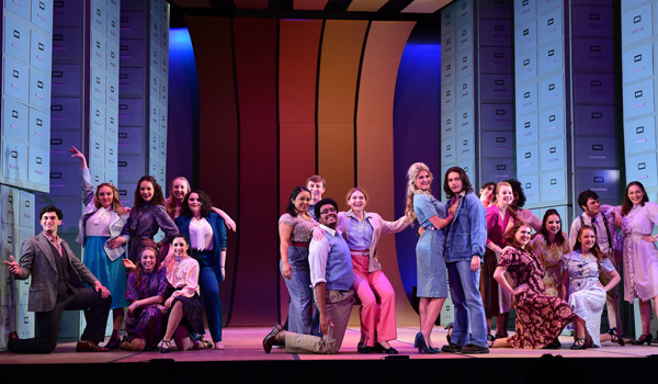 Students perform 9 to 5 the Musical on stage.