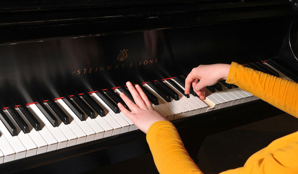 A Catholic University student practicing the piano.