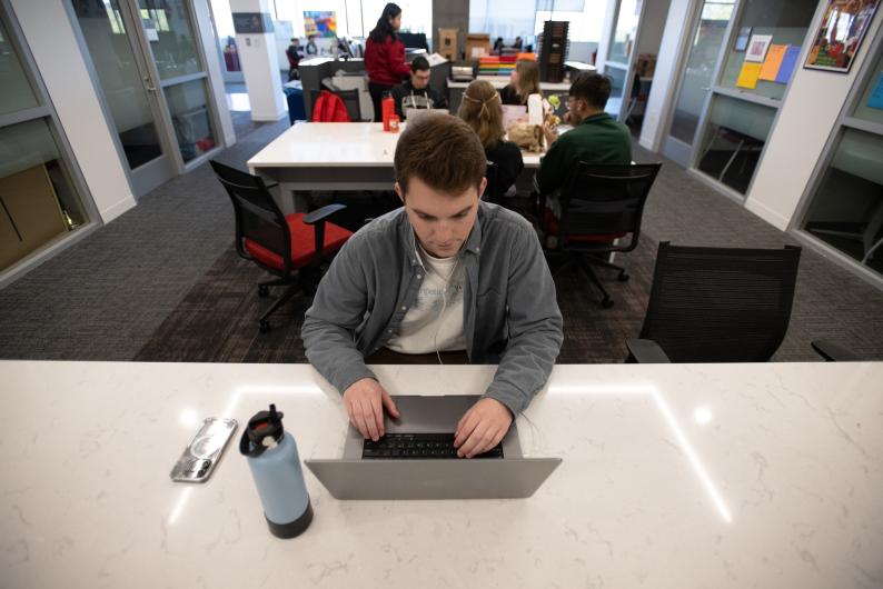 student on laptop in tech lab
